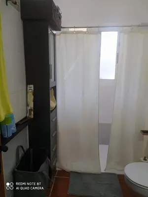 a bathroom with a shower curtain and a toilet at Habitación privada en casa particular, montaña in Olesa de Bonesvalls