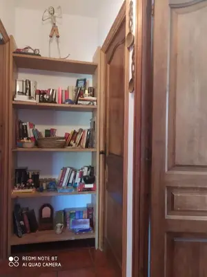 a book shelf with books on it next to a door at Habitación privada en casa particular, montaña in Olesa de Bonesvalls