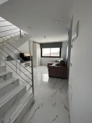 a living room with a staircase and a couch at Apartamentos Rosa de Abril in Teià