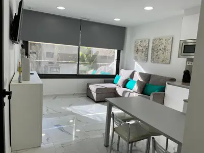 a living room with a couch and a table at Apartamentos Rosa de Abril in Teià