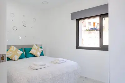 a white bedroom with a bed with towels on it at Apartamentos Rosa de Abril in Teià