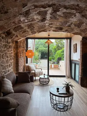 a living room with a couch and a table at Suíte Sant Sebastià con jacuzzi, sauna y jardín in Moià