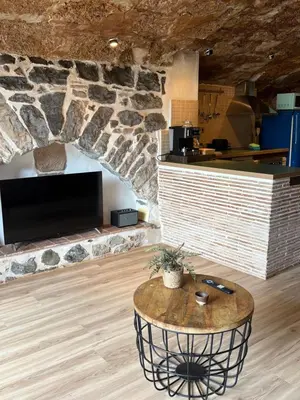 a room with a table and a stone wall at Suíte Sant Sebastià con jacuzzi, sauna y jardín in Moià