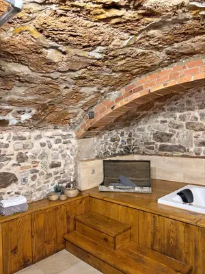 a stone kitchen with a sink and a stone wall at Suíte Sant Sebastià con jacuzzi, sauna y jardín in Moià