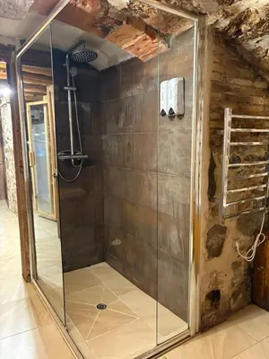 a shower with a glass door in a room at Suíte Sant Sebastià con jacuzzi, sauna y jardín in Moià