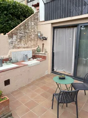 a patio with a table and a bench and a sink at Suíte Sant Sebastià con jacuzzi, sauna y jardín in Moià