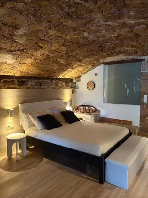 a bedroom with a large bed and a large screen at Suíte Sant Sebastià con jacuzzi, sauna y jardín in Moià