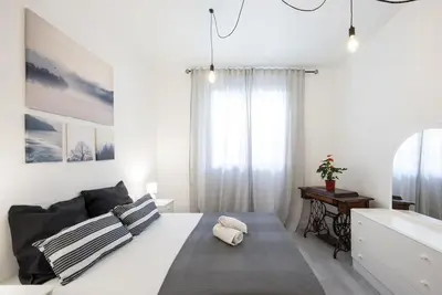 a white bedroom with a large bed and a window at Llorens Sagrada Familia in Barcelona