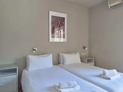 two beds in a room with white sheets and towels at Stay U-nique Apartments Torre Damians in Barcelona