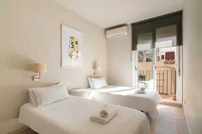 two white beds in a room with a window at Stay U-nique Apartments Torre Damians in Barcelona