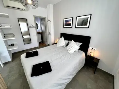 a bedroom with a large white bed with black pillows at Loft moderno en buena ubicación in Terrassa
