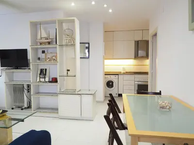 a kitchen and dining room with a glass table at Sunflower Apartment by Hello Homes Sitges in Sitges