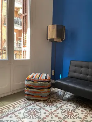a living room with a black couch and a ottoman at Caliu Apartments Barcelona - Camp Nou in Hospitalet de Llobregat