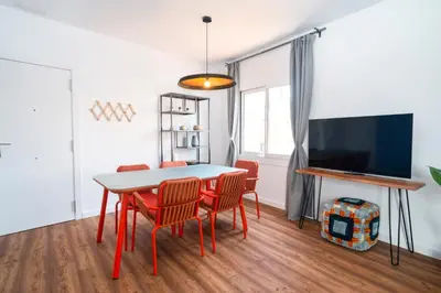 a dining room with a table and chairs and a tv at Caliu Apartments Barcelona - Camp Nou in Hospitalet de Llobregat