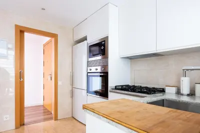 a kitchen with white cabinets and a stove top oven at Casa Natura Gava Beach in Gavà