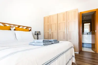 a bedroom with a white bed with towels on it at Casa Natura Gava Beach in Gavà
