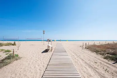 a boardwalk on a beach with the ocean in the background at Casa Natura Gava Beach in Gavà