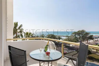 a table on a balcony with a view of the ocean at Sitges ARENA - dos piscinas frente al mar in Sitges