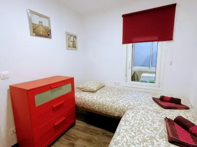 a bedroom with two beds and a red dresser at Magnifico Apartamento Barca 4 in Sant Adria de Besos