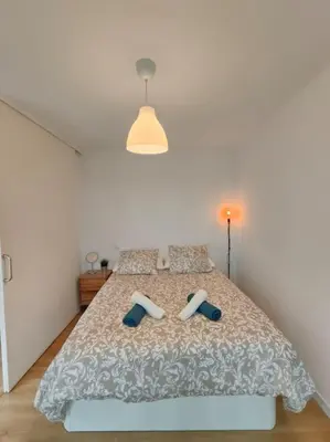 a bedroom with a bed with blue slippers on it at Cute apartment Sant Adria beach in Sant Adria de Besos