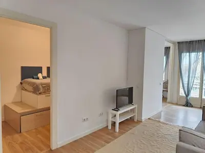 a living room with a bed and a mirror at Cute apartment Sant Adria beach in Sant Adria de Besos