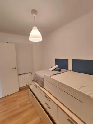 a bedroom with two beds and a light at Cute apartment Sant Adria beach in Sant Adria de Besos