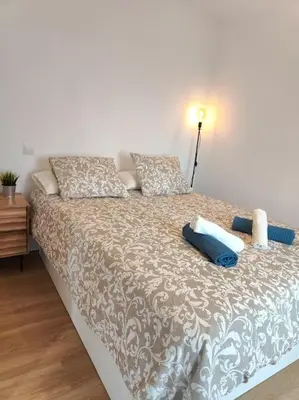 a bed with pillows on it in a room at Cute apartment Sant Adria beach in Sant Adria de Besos