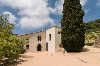 a building with a large tree in front of it at Romantic Stay in Grand Setting in Alella