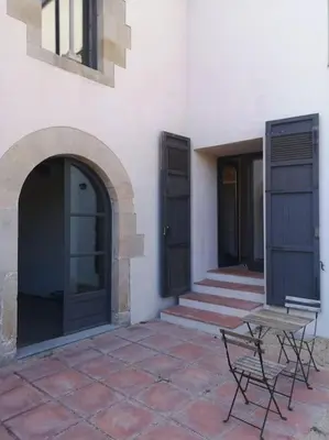 a building with two doors and a bench on a patio at Romantic Stay in Grand Setting in Alella