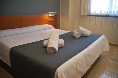 a hotel room with a bed with towels on it at Apartaments Independencia in Barcelona