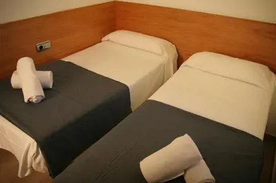 two beds in a small room with at Apartaments Independencia in Barcelona