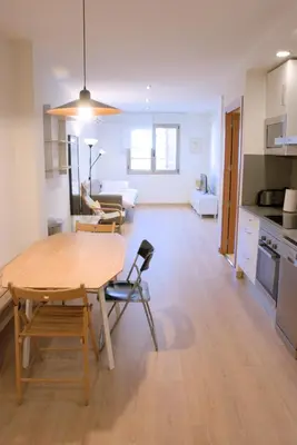 a kitchen and living room with a table and chairs at SWEET BCN Plaza Universidad in Barcelona