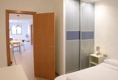 a bedroom with a closet and a bed and a table at SWEET BCN Plaza Universidad in Barcelona