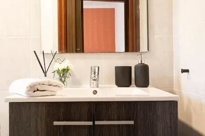 a bathroom with a white sink and a mirror at Lodging Apartments Barceloneta Mar in Barcelona