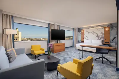 a lobby with chairs and tables and large windows at Hilton Barcelona in Barcelona