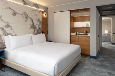 a hotel room with a bed and a desk and a window at Hilton Barcelona in Barcelona