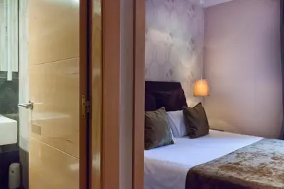 a bedroom with a bed with white sheets and pillows at Casa Boutique Barcelona in Barcelona