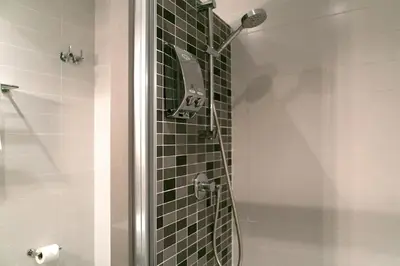 a shower in a bathroom with green tile at Blanc Guest House in Barcelona