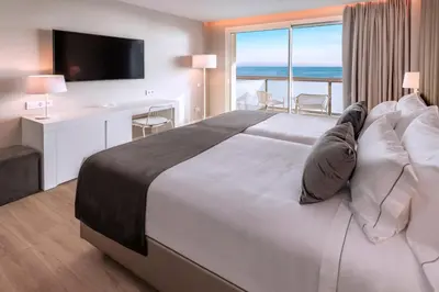 a bedroom with a large bed with a view of the ocean at Hotel Playafels in Castelldefels