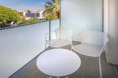 two white chairs and a table on a balcony at Hotel Playafels in Castelldefels