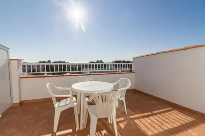 a balcony with a white table and chairs on it at Apartamentos Sunway Amapola in Sitges
