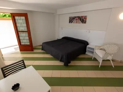 a bedroom with a bed and a table and a chair at Apartamentos Sunway Amapola in Sitges