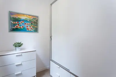 a bathroom with a white cabinet and a painting on the wall at Gracia Terrace in Barcelona