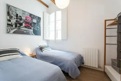 a bedroom with two beds and a window at Gracia Terrace in Barcelona