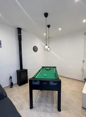a room with a pool table and a fireplace at Apartamento St Zenon in Arenys de Mar