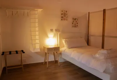 a bedroom with a bed and a lamp on a table at MonResidence La Figuereta in Manresa