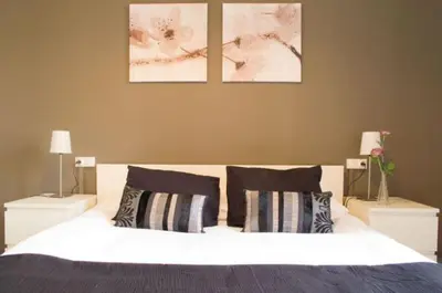a bedroom with a bed with two nightstands and two pictures at Barcelonaguest in Barcelona