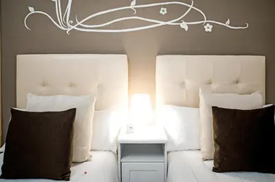 a bedroom with two beds with white pillows at Petit Hotel in Barcelona