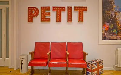 two red chairs in front of a wall with a sign at Petit Hotel in Barcelona