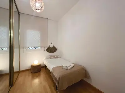 a small bedroom with a bed and a lamp at Hauzify I Apartament Can Reig in San Pol de Mar